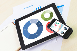 digital tablet and smartphone with financial chart report, paper